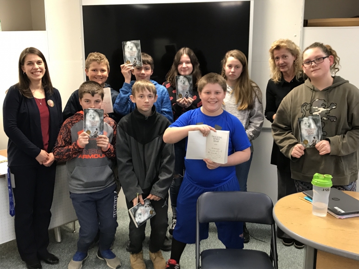 Students in the class hold autographed copies of the book, “Touching Spirit Bear,” by Ben Mikaelsen. The students connected with the author via distance learning connection at their school.