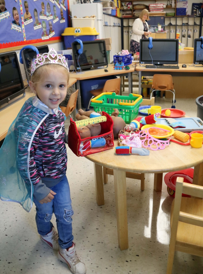 During pre-K orientation, Briar Wielt found the toy station in her new classroom, where she put on a princess cape and crown as she familiarized herself with the room.