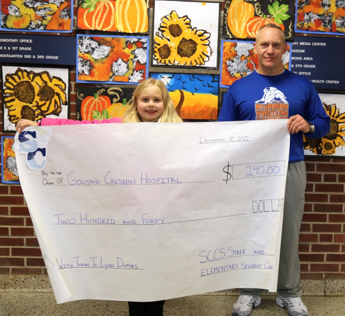Staff and student council at Sandy Creek Elementary were inspired to donate to Golisano Children’s Hospital after learning of Lynn Dumas’ generosity when she used the money she had raised to buy gifts for patients at the hospital. Pictured following a presentation at the school are Lynn Dumas with William “Bill” Benedict, a teacher at Sandy Creek Elementary School who coordinated the donation for Lynn’s cause.
