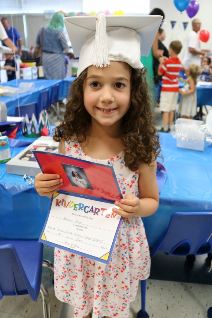 Allison Jones shows off her certificate certifying her successful completion of kindergarten during the classroom celebration that followed her "Kindergarten Graduation". Jones is a student in Teira Norton's class at Sandy Creek Elementary School.