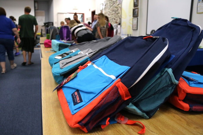 Families and students pick out their favorite backpack filled with supplies based on their grade level at the annual school supply distribution day in the Sandy Creek District.