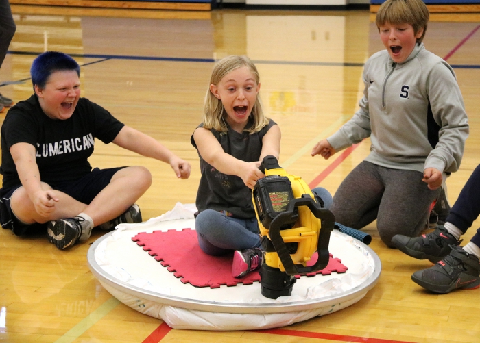 Elizabeth Dano, center, reacts in surprise to the inaugural run of her team’s hovercraft. In back are Kayden Trumble, left and Elizabeth Hobbs, two members of Dano’s team.