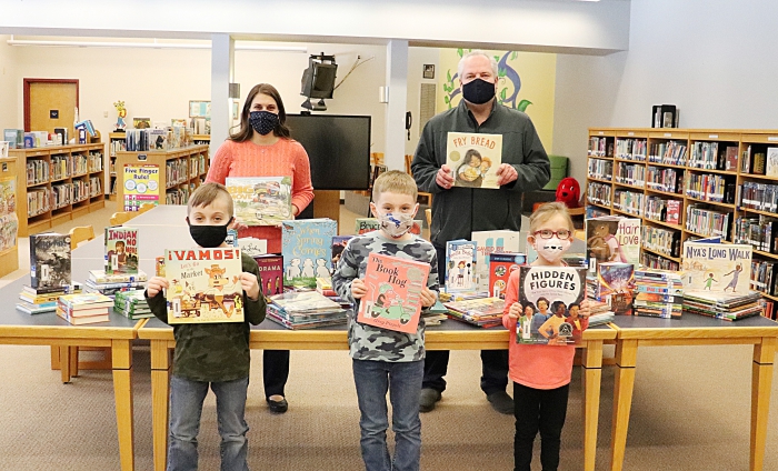 Pictured with the books purchased from a recent donation are Sandy Creek students, school librarian Rachel Allen, top row at left, and Shawn Massey, top row at right, whose business donated the money that allowed the district to purchase nearly 150 unique titles.