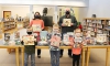 Pictured with the books purchased from a recent donation are Sandy Creek students, school librarian Rachel Allen, top row at left, and Shawn Massey, top row at right, whose business donated the money that allowed the district to purchase nearly 150 unique titles.