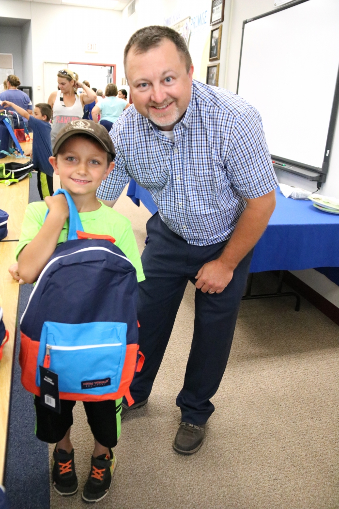 Principal Timothy Filatrault was on hand to assist and greet students at the school supply distribution. Filiatrault is the new Elementary School Principal and he is pictured with Alex Oatman who will be a second grader in the school this year.