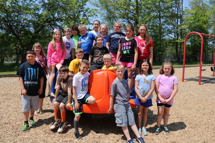 Members of the Sandy Creek Elementary Climate Committee are pictured on the new piece of playground equipment the group purchased and donated to the school. Committee adviser Judy Allen is pictured at back left.