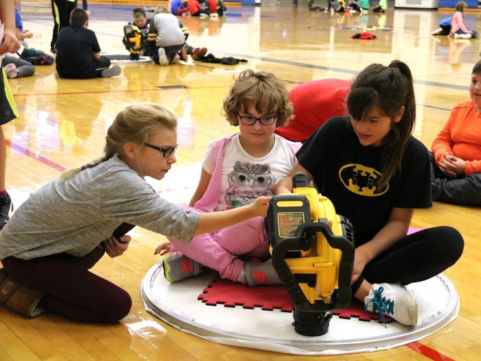 Sara Leppien, left, shows Kelsey Ridgeway and Destiny Urquhart how to engage the blower to activate the hovercraft.