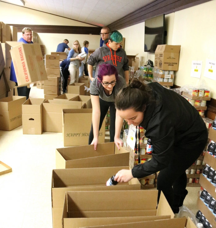 Boxes of food for a holiday meal were packed by students and community members in assembly line fashion during a recent community service project to provide a happy holiday to needy families in the Sandy Creek School District area.