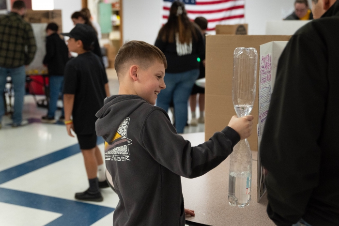 A fifth grader at SCCS shows off his science fair project during STEAM Family Fun Night. 