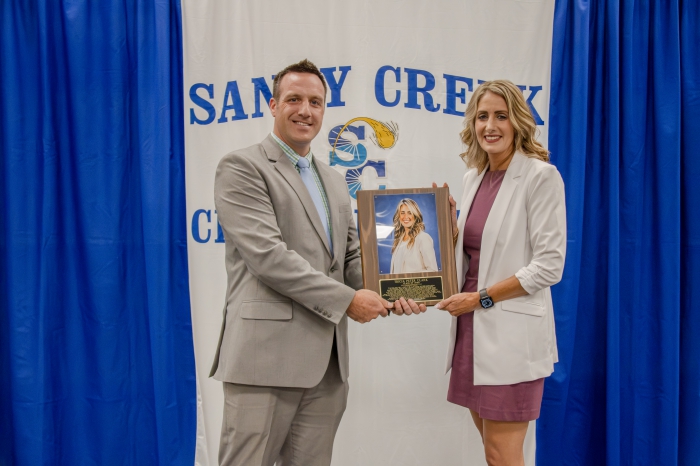 SCCS Superintendent Kevin Seymour presents Tricia Peter Clark, class of 2000, with her Wall of Distinction induction plaque.